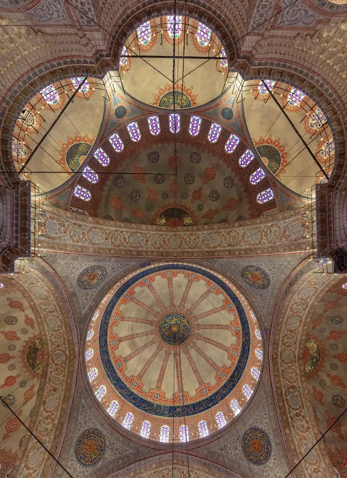 The domes and stained glass inside the Blue Mosque in Istanbul, where Turkey tour packages ask you to dress for a mosque visit