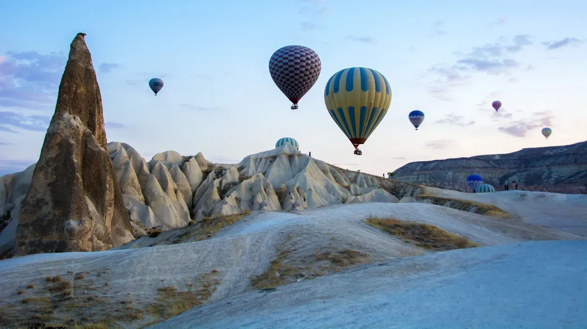 Hot air balloons over the fairy chimneys of Goreme at dawn, the view on 2 and 3 day Cappadocia tour packages from Istanbul